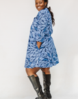 Model wearing blue shaded leaf print dress.