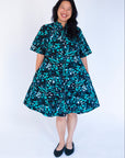 Model wearing abstract blue pebble print dress.