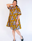 Model wearing orange and purple dress.