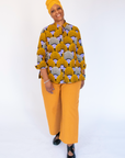 Model wearing long sleeved orange and purple geometric print shirt.