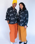 Model wearing black long sleeved shirt with white music print design.