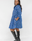 Model wearing black and blue floral dress.