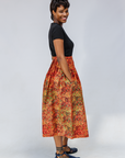 Model wearing multicolored dot print skirt.