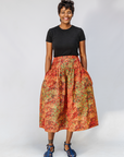 Model wearing multicolored dot print skirt.