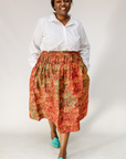 Model wearing multicolored dot print skirt.