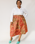Model wearing multicolored dot print skirt.