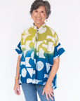 Model wearing yellow, green and blue geometric print batik shirt.