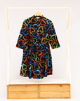 Display of black dress with multicolored heart print pattern.
