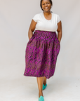 Model wearing fuchsia skirt with small dot design.