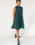 Model wearing sleeveless black dress with teal moon design.