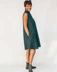 Model wearing sleeveless black dress with teal moon design.