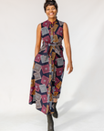 Model wearing pink, orange, white and black geometric print dress.
