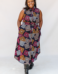 Model wearing pink, orange, white and black geometric print dress.