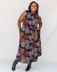 Model wearing pink, orange, white and black geometric print dress.