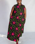 Model wearing navy and green dress with pink floral print.