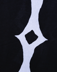 Close up display of black and white geometric print dress, fabric