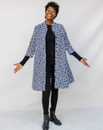 Model wearing blue and white swirl print dress.