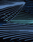 Close up display of black dress with aqua and navy abstract print, fabric.