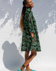 Model wearing green camo print like dress.