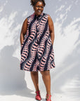 Model wearing black and pink sleeveless print dress.