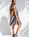 Model wearing black and pink sleeveless print dress.