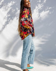 Model wearing multicolored puzzle print shirt.