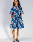 Woman wearing a blue patterned dress on a white background