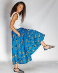 Model wearing white shirt with blue pants with beige fish print.