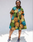 Model wearing black dress with orange, yellow, blue and green swirls.