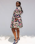 Model wearing colorful abstract print dress.