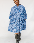 Model wearing blue shaded leaf print dress.