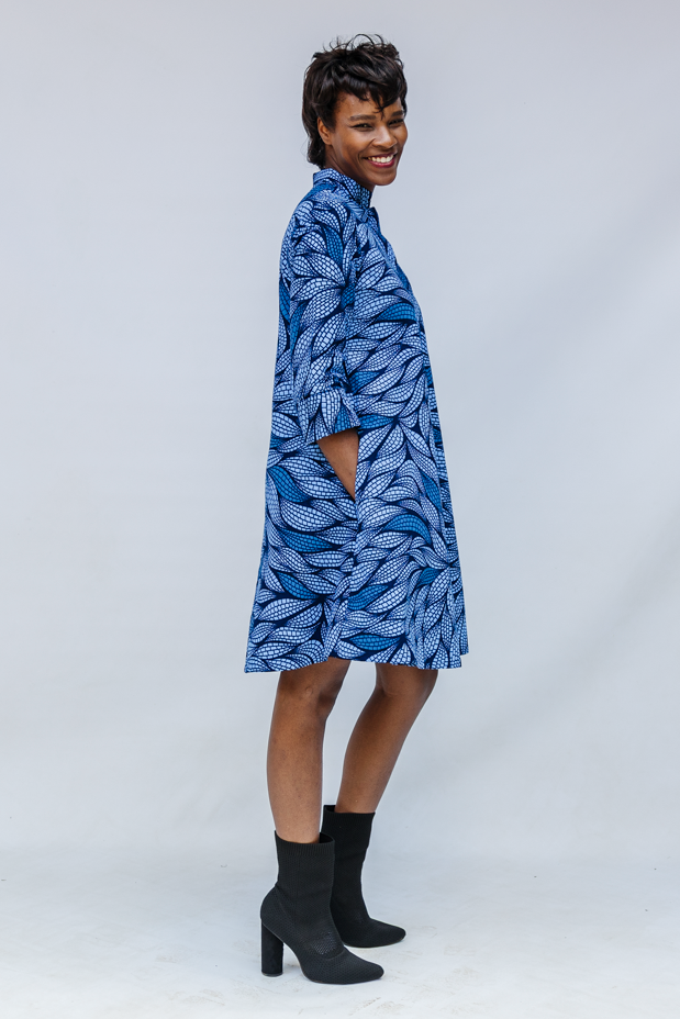 Model wearing blue shaded leaf print dress.