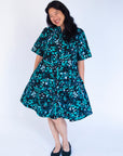 Model wearing abstract blue pebble print dress.