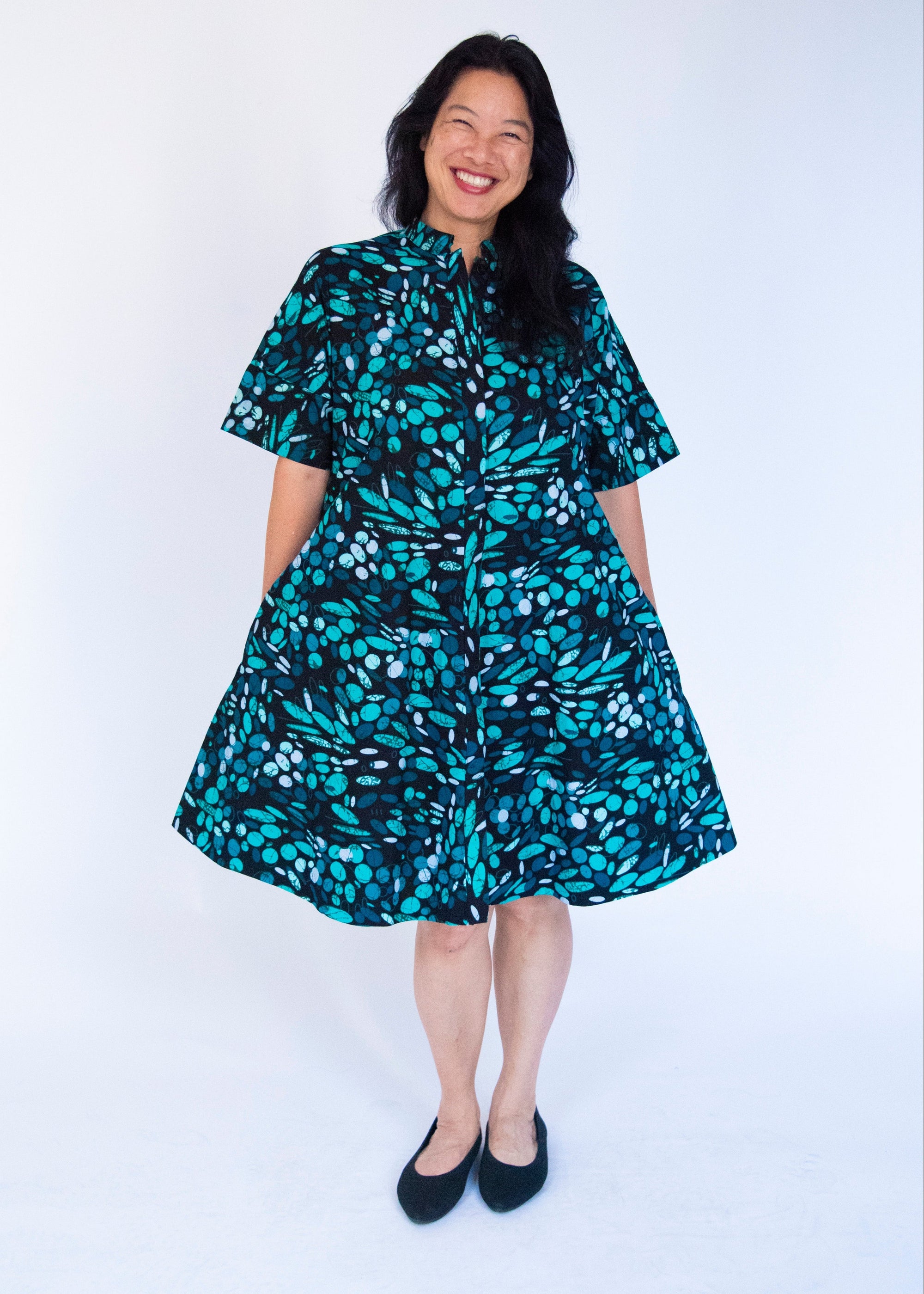 Model wearing abstract blue pebble print dress.