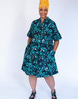Model wearing abstract blue pebble print dress.