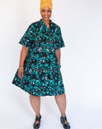 Model wearing abstract blue pebble print dress.