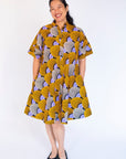 Model wearing orange and purple dress.