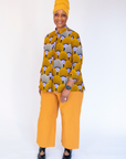 Model wearing long sleeved orange and purple geometric print shirt.
