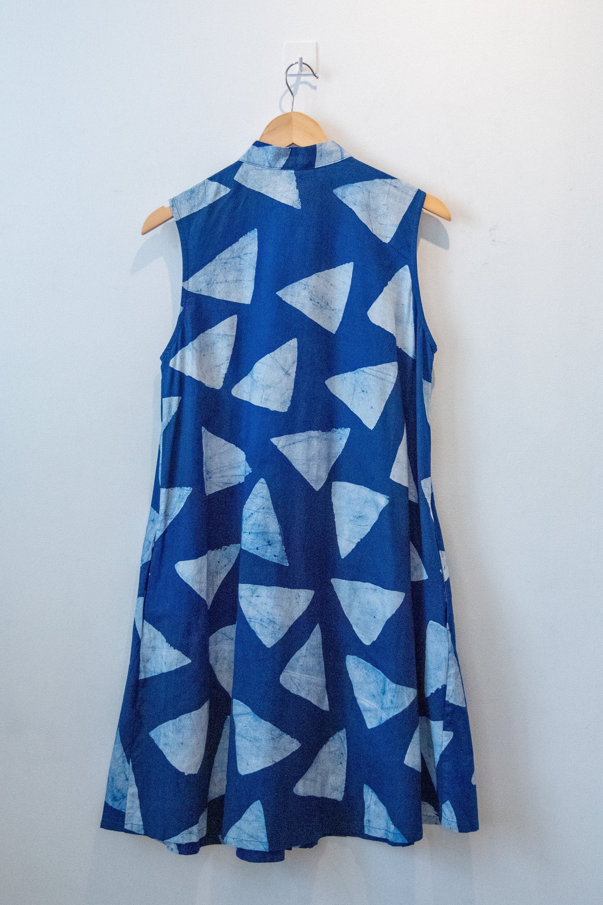 Display of blue sleeveless dress with white triangle print.