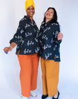 Model wearing black long sleeved shirt with white music print design.