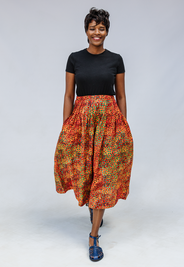 Model wearing multicolored dot print skirt.