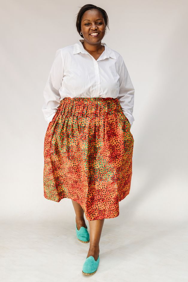 Model wearing multicolored dot print skirt.