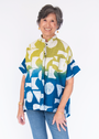 Model wearing yellow, green and blue geometric print batik shirt.