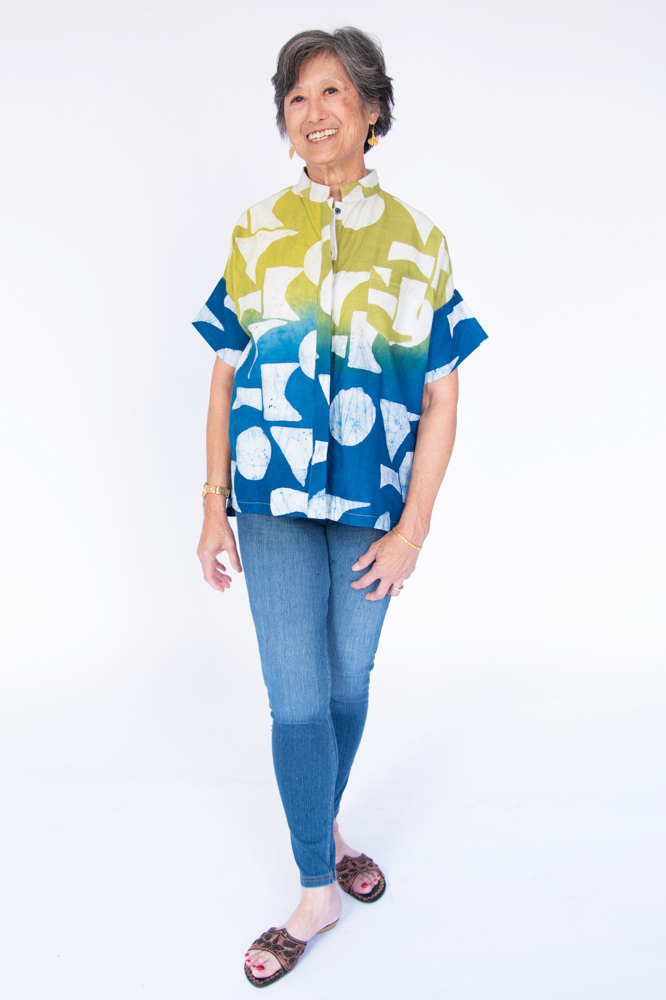 Model wearing yellow, green and blue geometric print batik shirt.