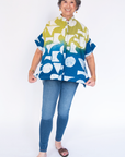 Model wearing yellow, green and blue geometric print batik shirt.