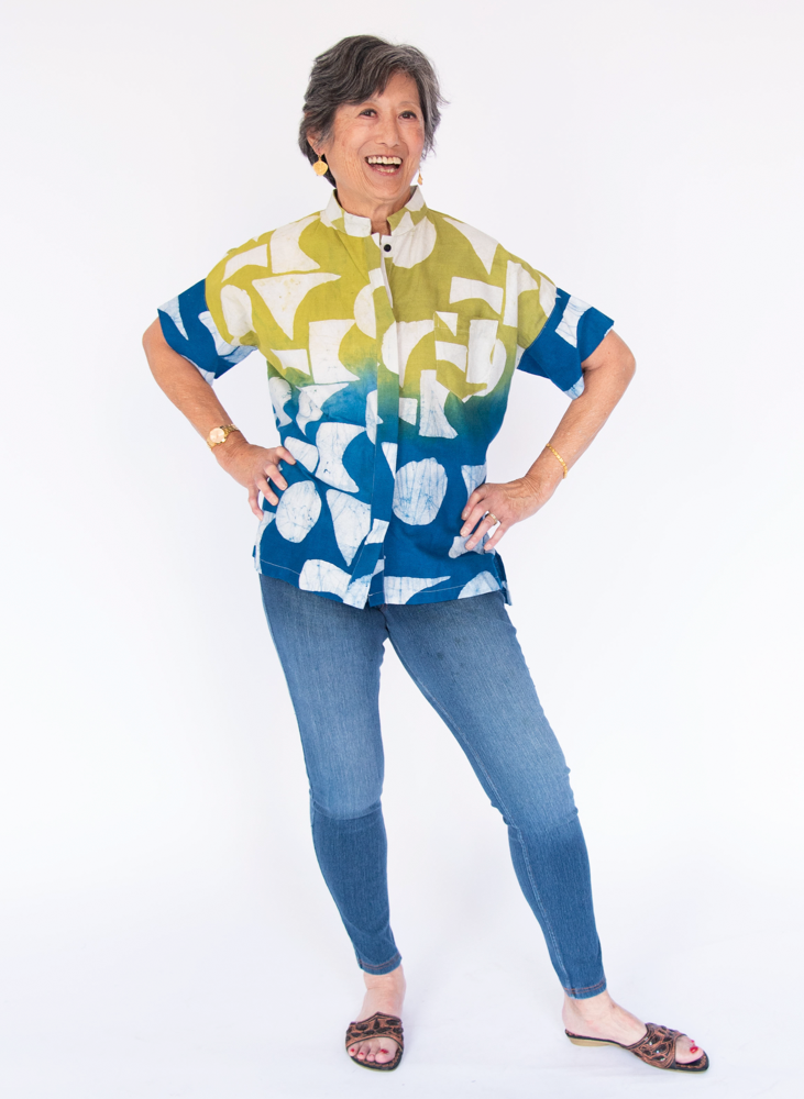 Model wearing yellow, green and blue geometric print batik shirt.
