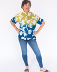 Model wearing yellow, green and blue geometric print batik shirt.