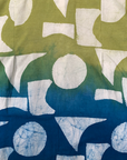 Close up display of yellow, green and blue geometric print batik shirt, fabric.