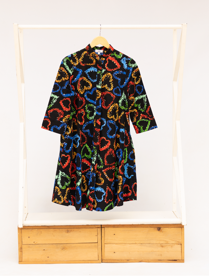 Display of black dress with multicolored heart print pattern.