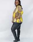 Model wearing yellow, brown and white abstract print shirt.